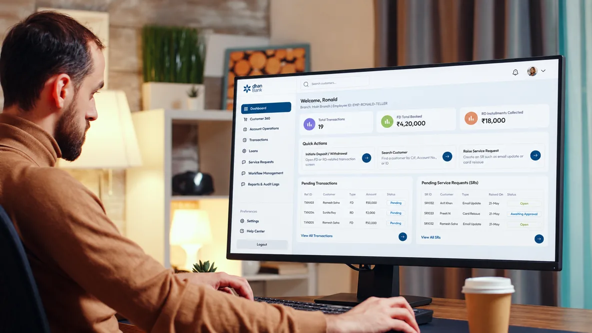 A man at a desktop monitor reviewing a banking operations dashboard of transactions and service requests