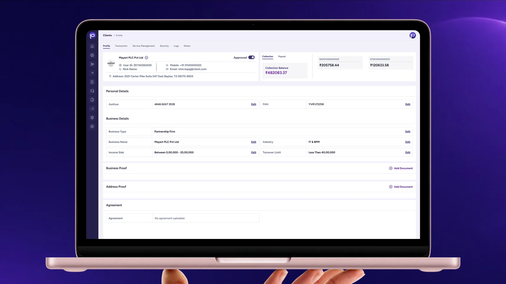 A laptop held in one hand showing the Paywize client profile screen