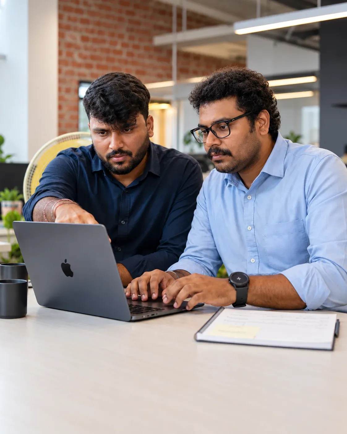 Zwei Zethic-Entwickler arbeiten gemeinsam an einem Laptop